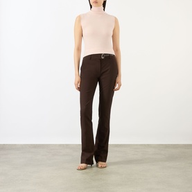 Model wearing Max Mara Sportmax cocoa flared trousers with belt, styled with a blush sleeveless turtleneck top and strappy heels.