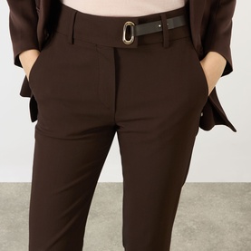 Model wearing Max Mara Sportmax cocoa tailored trousers with a black leather belt, styled with a matching cocoa blazer.