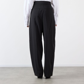 Model wearing Max Mara Sportmax Zorro Wide-Leg Trousers in black, rear view showing covered waistband and wide-leg silhouette, styled with white