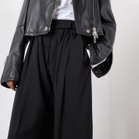 Model wearing Max Mara Sportmax Zorro Wide-Leg Trousers in black with gathered front detail, styled with a black leather jacket and white tee.