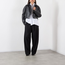 Model wearing Max Mara Sportmax Zorro Wide-Leg Trousers in black with white shirt and black leather jacket.
