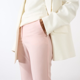 Model wearing Max Mara Sportmax Antique Rose wool trousers with zip detail, styled with a cream blazer.