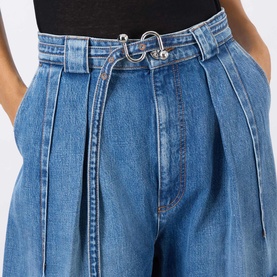 Model wearing Max Mara Sportmax midnight blue wide-leg denim trousers with front pleats and silver ring belt detail, styled with black top.