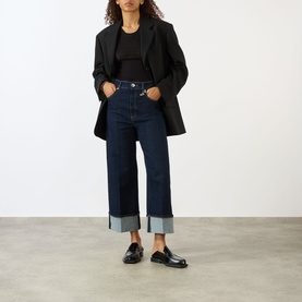 Model wearing Max Mara Sportmax ultramarine wide-leg cuffed denim jeans, styled with a black blazer and black loafers.