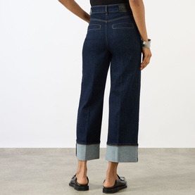 Model wearing Max Mara Sportmax Ultramarine wide-leg cropped jeans with deep contrast cuffed hem, styled with black loafers.