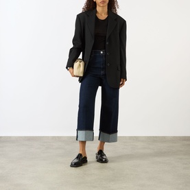 Model wearing Max Mara Sportmax ultramarine wide-leg cuffed denim trousers, styled with black blazer, black top and black loafers.