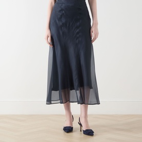 Model wearing Piano Forte Astrale Organza Skirt in Midnight Blue, midi length with sheer organza layer, styled with navy heels