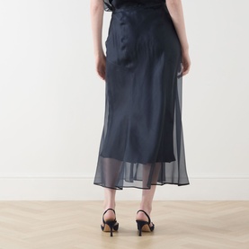 Model wearing Piano Forte Astrale Organza Skirt in Midnight Blue; midi length, sheer organza layer, styled with black slingback heels.