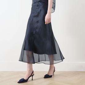 Model wearing Piano Forte Astrale Organza Skirt in Midnight Blue, midi length with sheer organza layer, styled with navy slingback heels