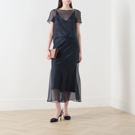 Model wearing Piano Forte Astrale Organza Skirt in Midnight Blue, midi length with sheer silk layer, styled with matching top and black heels