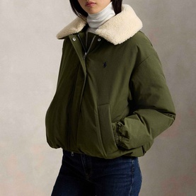 Model wearing Polo Ralph Lauren New Olive coat with shearling collar, styled with white turtleneck and blue jeans