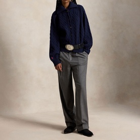 Model wearing Polo Ralph Lauren Hunter Navy cable-knit cardigan with grey wide-leg trousers and a western belt.