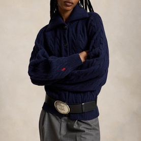 Model wearing Polo Ralph Lauren Hunter Navy cable-knit half-zip cardigan, styled with black leather belt and grey trousers