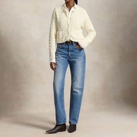 Model wearing Polo Ralph Lauren Clubhouse Cream cable-knit cardigan, styled with blue straight-leg jeans and dark ankle boots.