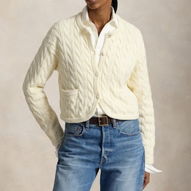 Model wearing Polo Ralph Lauren Clubhouse Cream cable-knit cardigan with button front, styled with white shirt and blue jeans.