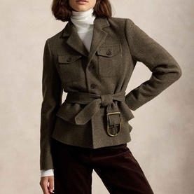 Model wearing Polo Ralph Lauren Belted Tweed Utility Jacket in Loden Herringbone with gold-tone buckle belt, styled with white turtleneck and dark