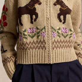 Model wearing Polo Ralph Lauren Multi cardigan with horse, floral and Fair Isle knit intarsia detail, styled with navy skirt