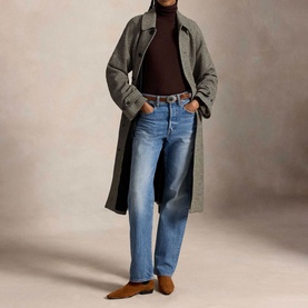 Model wearing Polo Ralph Lauren Black/Cream Herringbone Coat, styled with blue straight-leg jeans, brown turtleneck and tan suede loafers.
