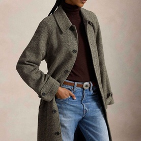 Model wearing Polo Ralph Lauren Black/Cream Herringbone Coat, styled with brown turtleneck, blue jeans and brown belt.