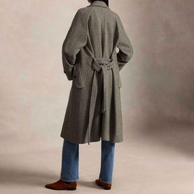 Model wearing Polo Ralph Lauren Black/Cream Herringbone Coat, back view with tie belt, styled with blue wide-leg jeans and brown suede loafers.