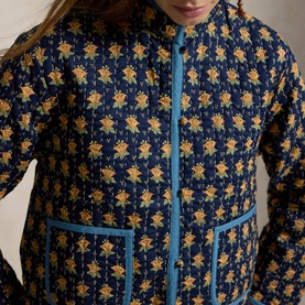 Model wearing Polo Ralph Lauren Navy Multi floral quilted jacket with blue contrast trim and button-front fastening