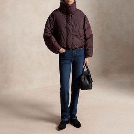 Model wearing Polo Ralph Lauren Dark Shadow Burgundy puffer coat, styled with dark wash jeans, black loafers, and carrying a black handbag.
