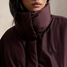 Model wearing Polo Ralph Lauren Dark Shadow Burgundy coat, close-up showing quilted high collar and embroidered Polo Pony logo.