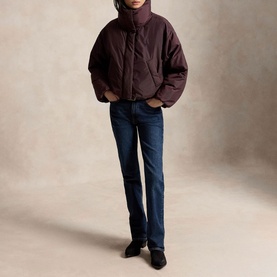 Model wearing Polo Ralph Lauren Dark Shadow Burgundy puffer coat with high neck, styled with dark blue jeans and black boots.