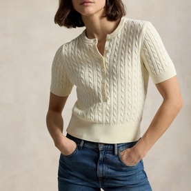 Model wearing Polo Ralph Lauren Clubhouse Cream cable-knit short-sleeve polo top, styled with blue denim jeans.