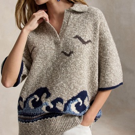 Model wearing Polo Ralph Lauren cream knit polo top with navy wave and seagull intarsia design, short sleeves, open collar