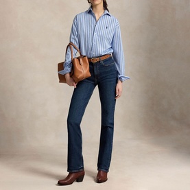 Model wearing Polo Ralph Lauren Blue/White striped shirt with dark indigo bootcut jeans, brown belt, and tan leather tote bag.