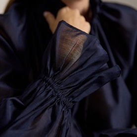 Model wearing Polo Ralph Lauren Hunter Navy shirt, featuring sheer puff sleeves with elasticated cuffs and deep V-neckline