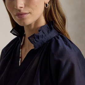 Model wearing Polo Ralph Lauren Hunter Navy shirt with ruffle collar detail, styled with hoop earrings and beaded necklace.