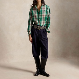 Model wearing Polo Ralph Lauren green and cream plaid shirt, styled with navy tapered trousers, western belt and black knee-high boots