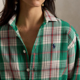 Model wearing Polo Ralph Lauren green and cream plaid shirt with embroidered logo, button-front detail and open collar.