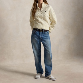 Model wearing Polo Ralph Lauren Authentic Cream cable-knit half-zip jumper, styled with mid-wash straight jeans and white trainers.