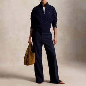 Model wearing Polo Ralph Lauren Hunter Navy cable-knit zip-neck jumper with navy wide-leg trousers, carrying a tan suede shoulder bag
