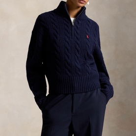 Model wearing Polo Ralph Lauren Hunter Navy cable-knit half-zip jumper with red pony logo, styled with navy trousers.