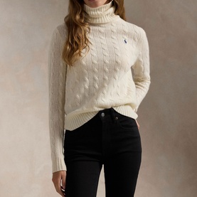 Model wearing Polo Ralph Lauren Authentic Cream cable-knit turtleneck sweater with embroidered pony logo, styled with black jeans.