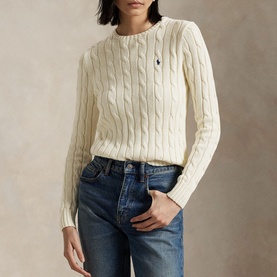 Model wearing Polo Ralph Lauren Authentic Cream cable-knit sweater with embroidered pony logo, styled with blue denim jeans.