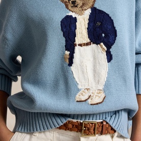 Model wearing Polo Ralph Lauren Blue Note knit sweater with embroidered Polo Bear motif, styled with brown leather belt