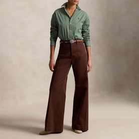 Model wearing Polo Ralph Lauren green and white striped shirt with brown wide-leg trousers and a woven belt.