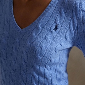 Model wearing Polo Ralph Lauren blue cable-knit V-neck sweater with embroidered pony logo at chest