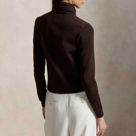 Model wearing Polo Ralph Lauren Deep Chocolate Melange turtleneck knit, back view, styled with white wide-leg trousers.