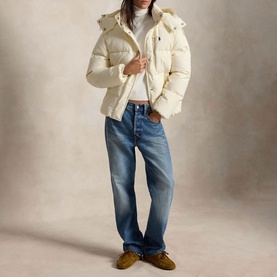 Model wearing Polo Ralph Lauren Estate Cream puffer coat with hood, styled with blue straight-leg jeans and tan suede shoes