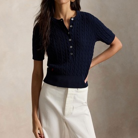 Model wearing Polo Ralph Lauren Hunter Navy cable-knit short-sleeve henley top, styled with white wide-leg trousers