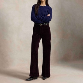 Model wearing Polo Ralph Lauren Midnight Merlot wide-leg trousers, styled with navy cable-knit sweater and black belt and heels.