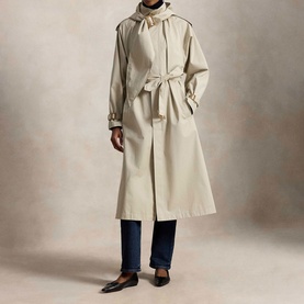 Model wearing Polo Ralph Lauren Buckled Scarf Hooded Trench Coat in Classic Stone with self-belt, styled with navy trousers and black loafers