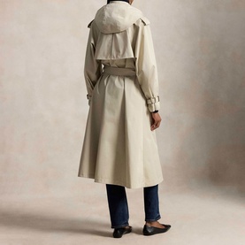 Model wearing Polo Ralph Lauren Buckled Scarf Hooded Trench Coat in Classic Stone, back view, with blue jeans and black flat shoes.