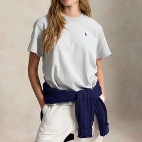 Model wearing Polo Ralph Lauren Grey Ash Heather T-Shirt with white trousers and navy cable-knit jumper tied at waist.